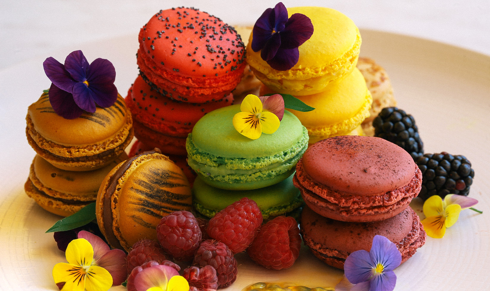 Different colors and designs of macarons with flowers, culinary arts, ready to eat. 