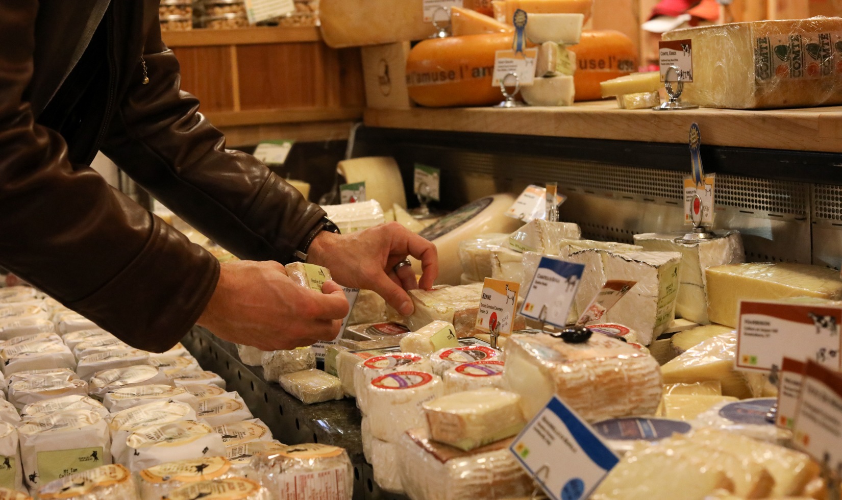 a person wrapping the cheese and putting tags