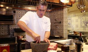 Jordan Winery Executive Chef Todd Knoll mashing herbs with a mortar and pestle in Jordan Winery Kitchen
