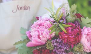 close up of a floral arrangement with peonies, roses and poppy pods