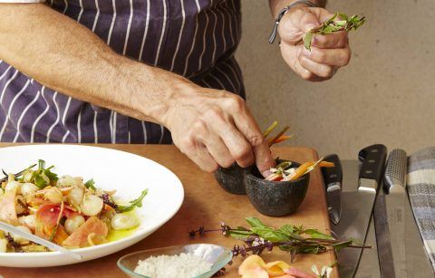 close up of Chef adding garnish to a plated appetizer