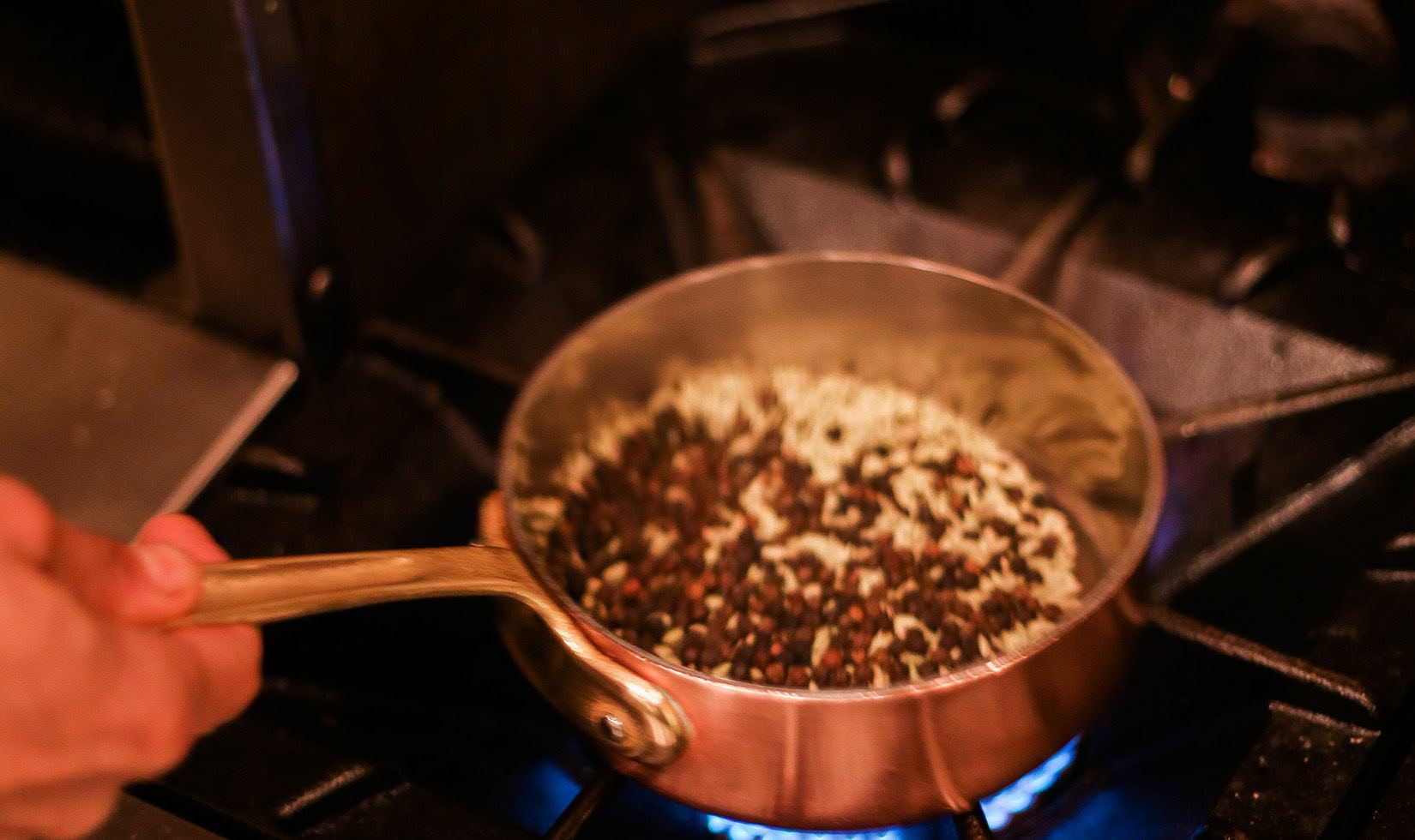 a person stir-frying the spices for porchetta recipe