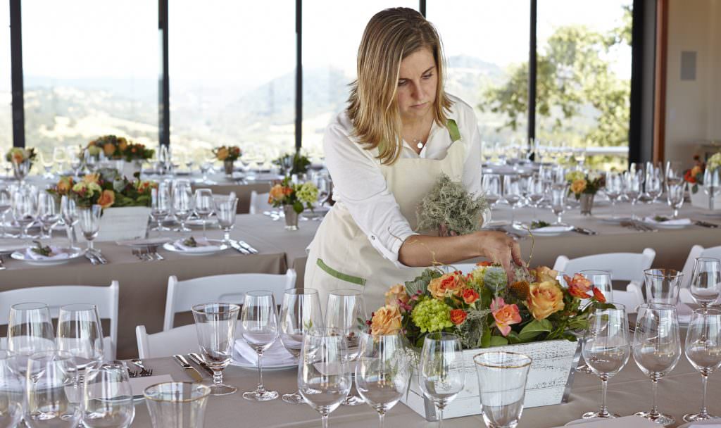Director of Hospitality Nitsa Knoll arranging a floral centerpiece for Jordan's annual Sunset Supper at Vista Point