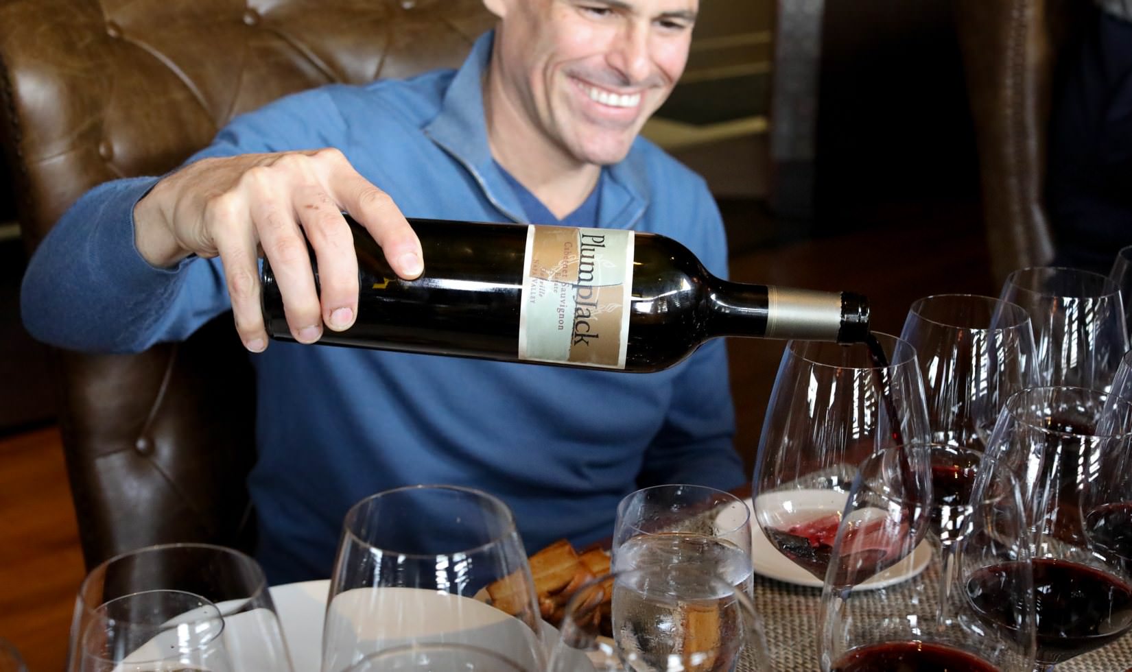 Jordan Winery Executive Chef Todd Knoll pouring Plumpjack Cabernet Sauvignon into a glass.