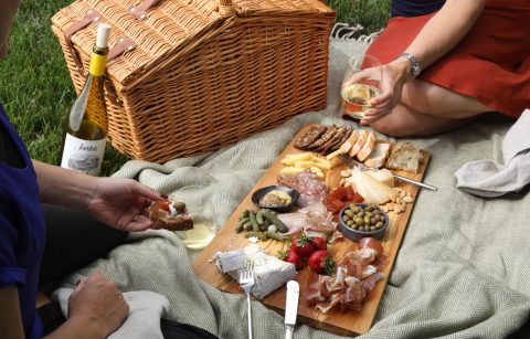 two people picnicking with a cheese and charcuterie board and Jordan Winery Chardonnay