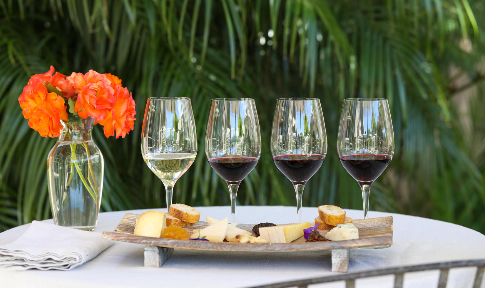 4 wine glasses with wine and cheese varieties in the table