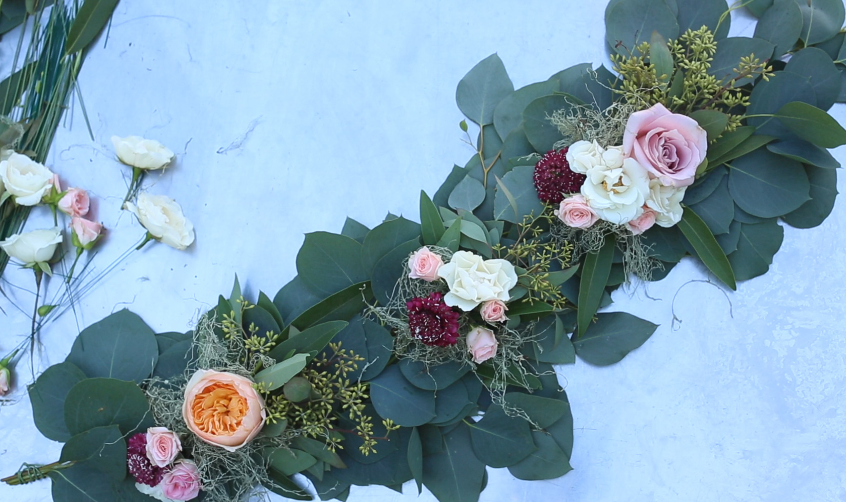 Finished greenery garland table runner with mini flower bouquets