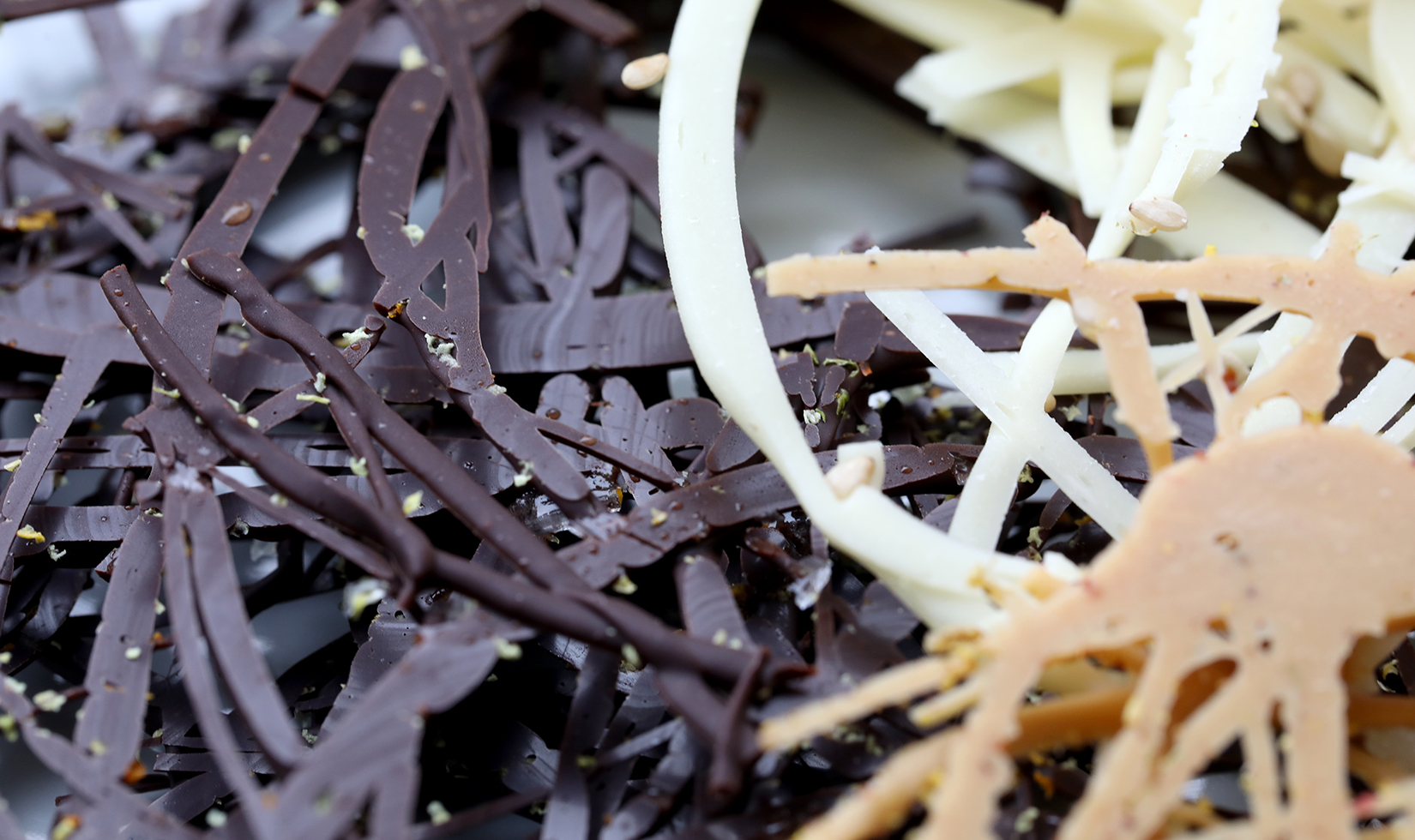 Decorative chocolate swirls with dark, white and dolce chocolate.