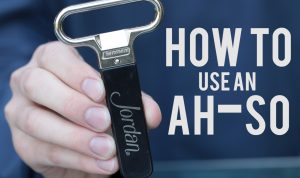 hand holding a Jordan Winery logo ah-so wine bottle opener with image text "how to use an ah-so"