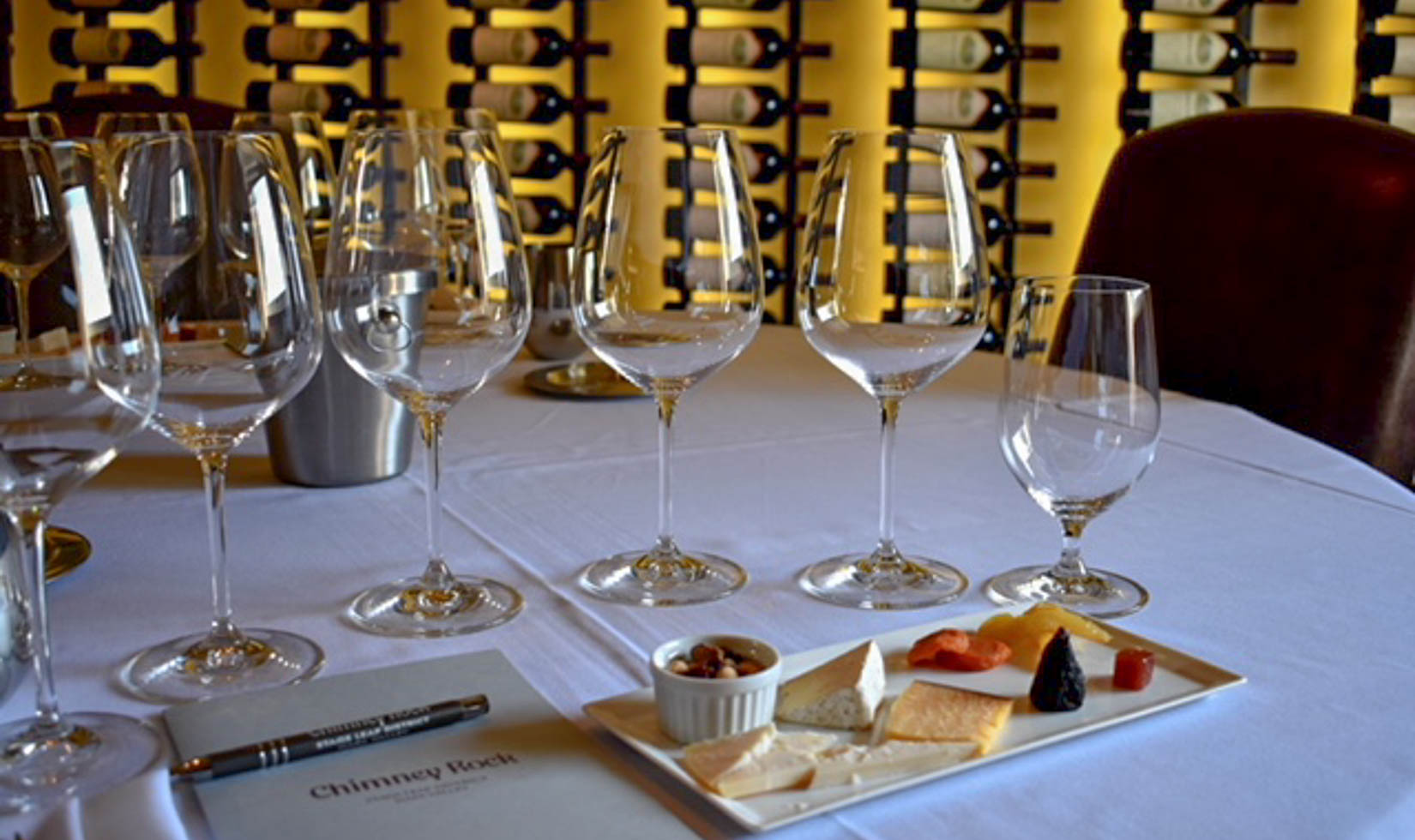 6 wine glasses with delicious varieties of cheese in a table with menu list