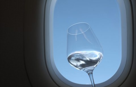 Glass of Chardonnay with airplane window in background
