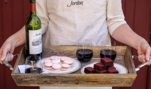 tray of desserts and Jordan Cabernet being held by someone in a Jordan cooking apron