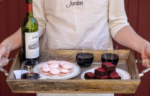tray of desserts and Jordan Cabernet being held by someone in a Jordan cooking apron