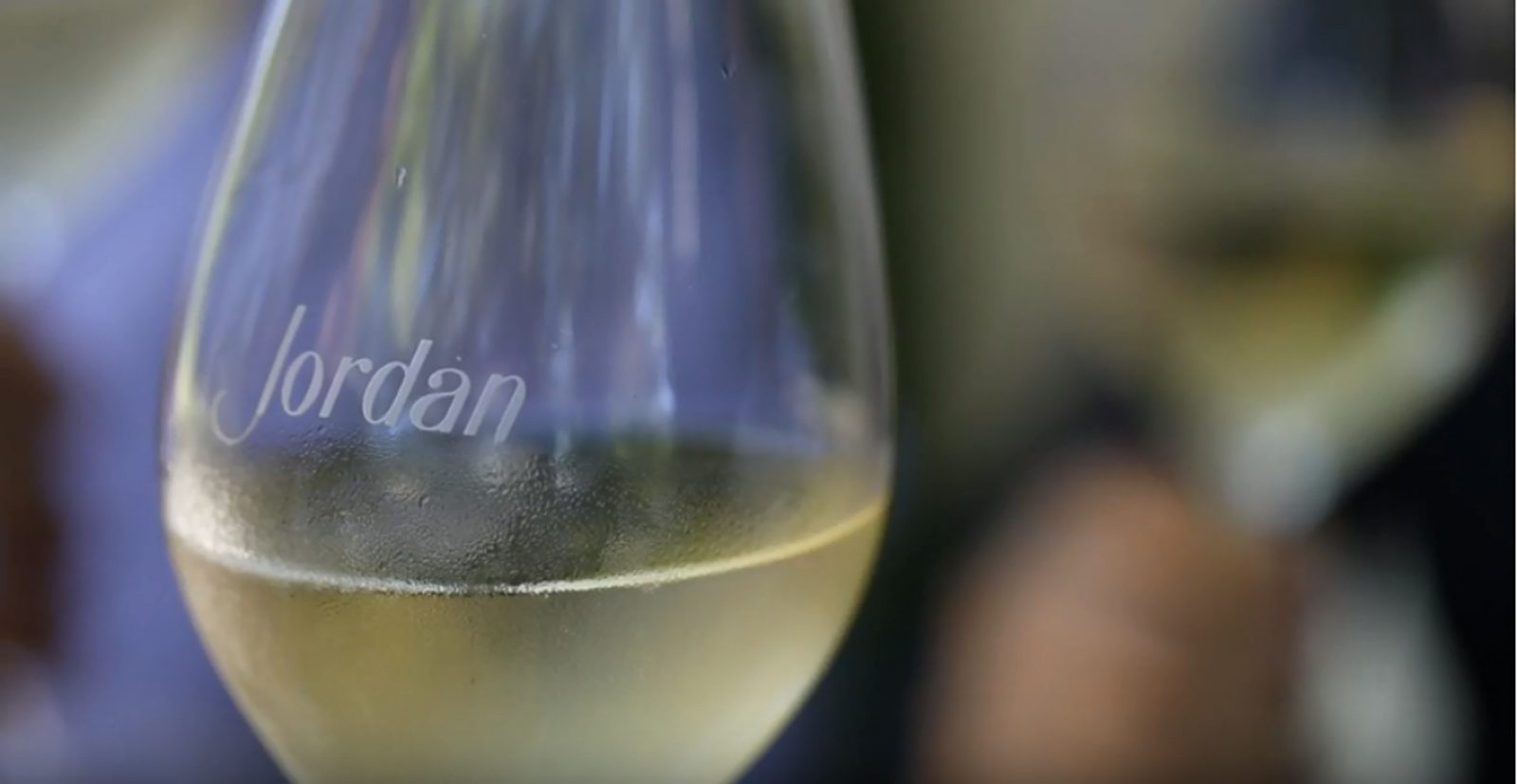 close up of a Jordan Winery etched wine glass with chilled Chardonnay in ti