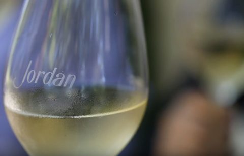 close up of a Jordan Winery etched wine glass with chilled Chardonnay in ti