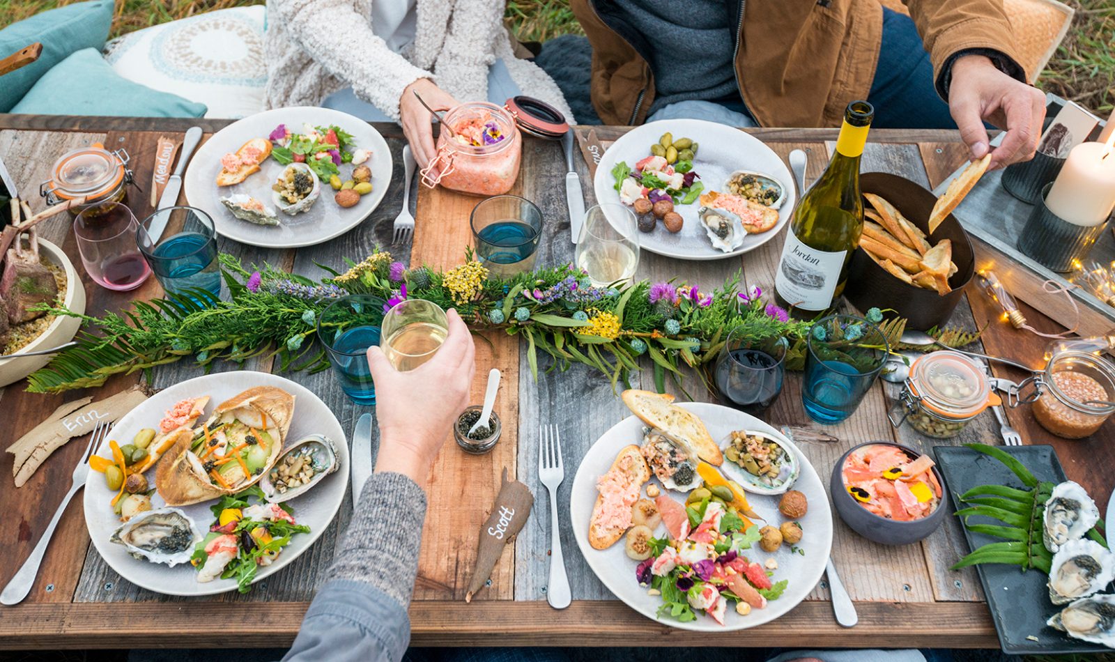 Full plates with crab salad, potatoes, salmon rillette and more at a coastal picnic