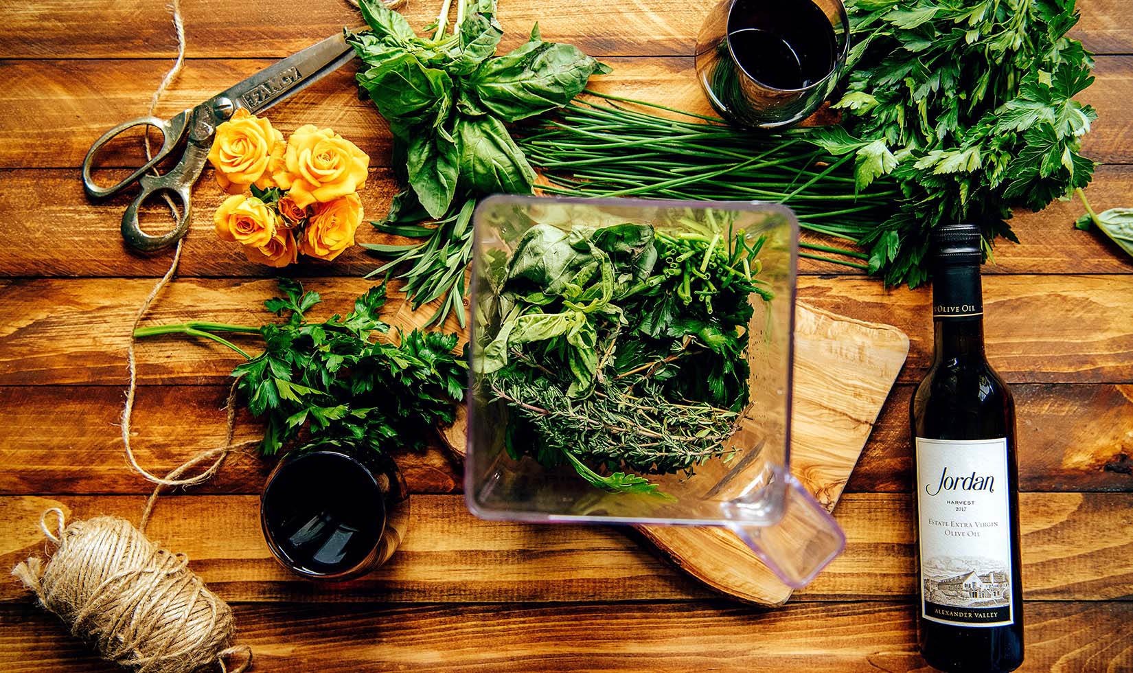 Fresh herbs and olive oil in a blender for creating herb-infused olive oil