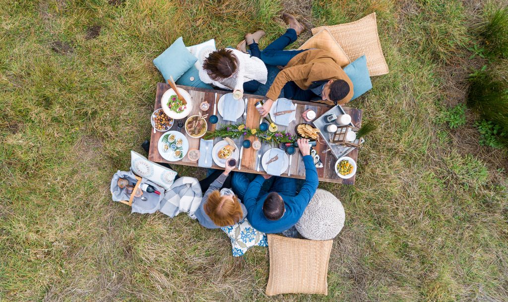 Drone shot of table with four people eating and drinking wine
