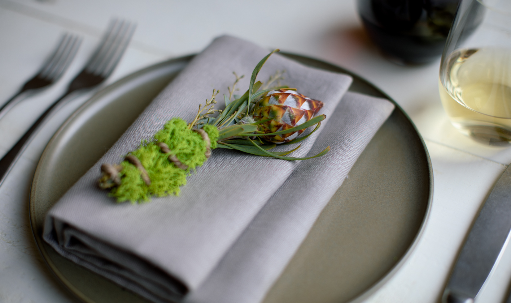 Rubeum Leucadendron and moss place setting on plate