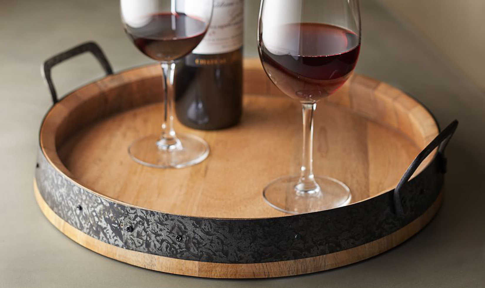 stemmed glasses with red wine on barrel top serving tray