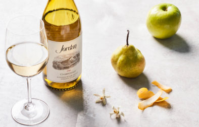 Jordan Winery 2018 Chardonnay next to a pear and a green apple