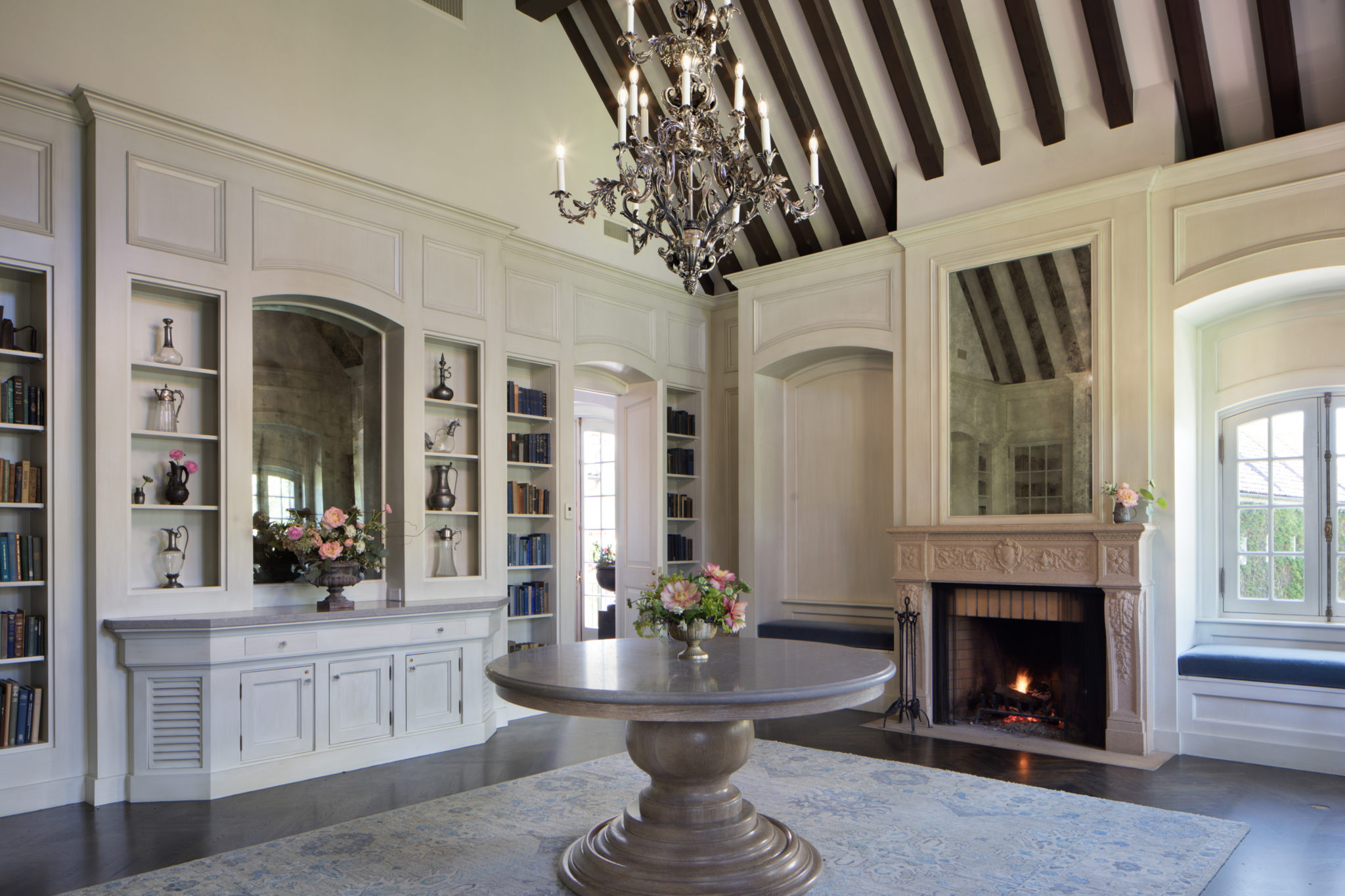 white library room with books chandelier and fireplace