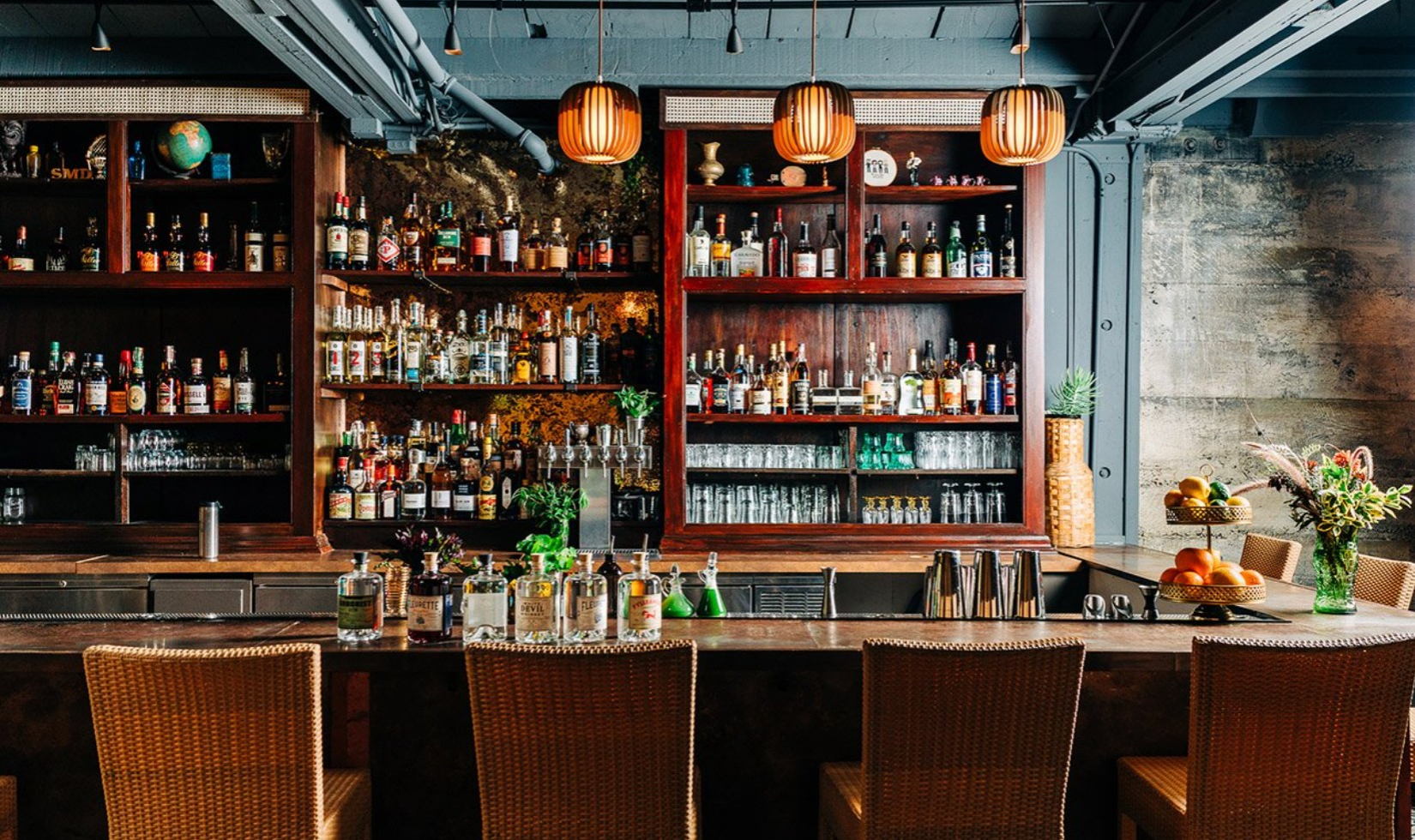 Bar with wooden shelves lined with bottles of spirits in contemporary restaurant
