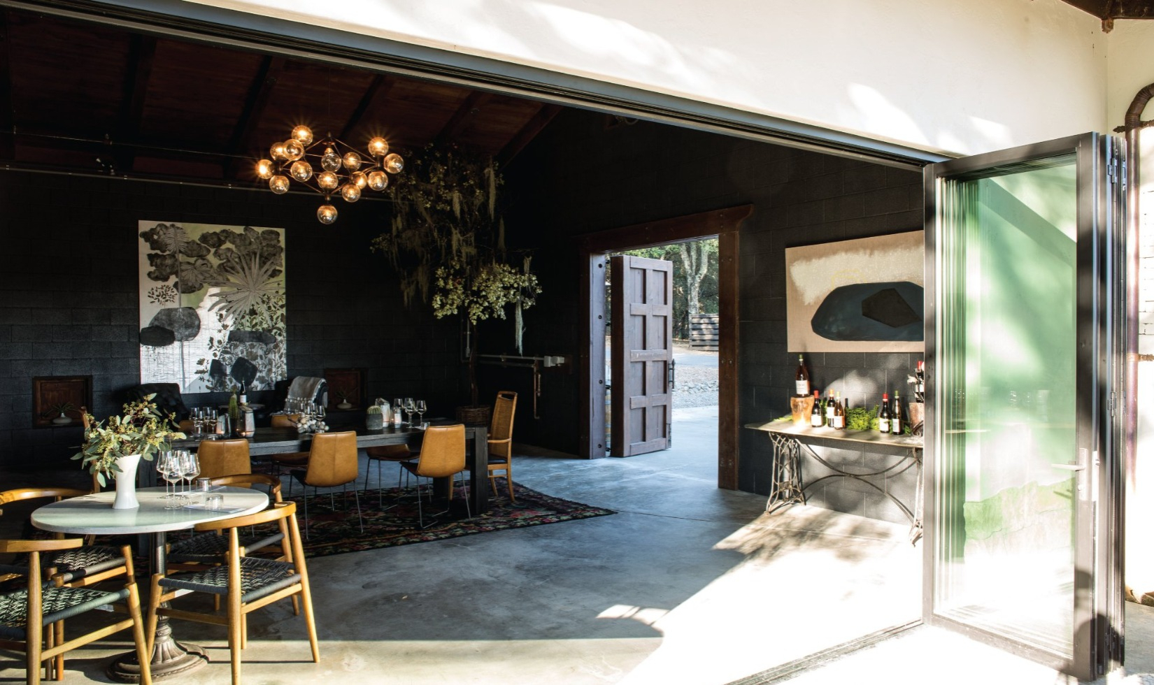 Reeve tasting room with bohemian furniture and concrete floors with door open to terrace.