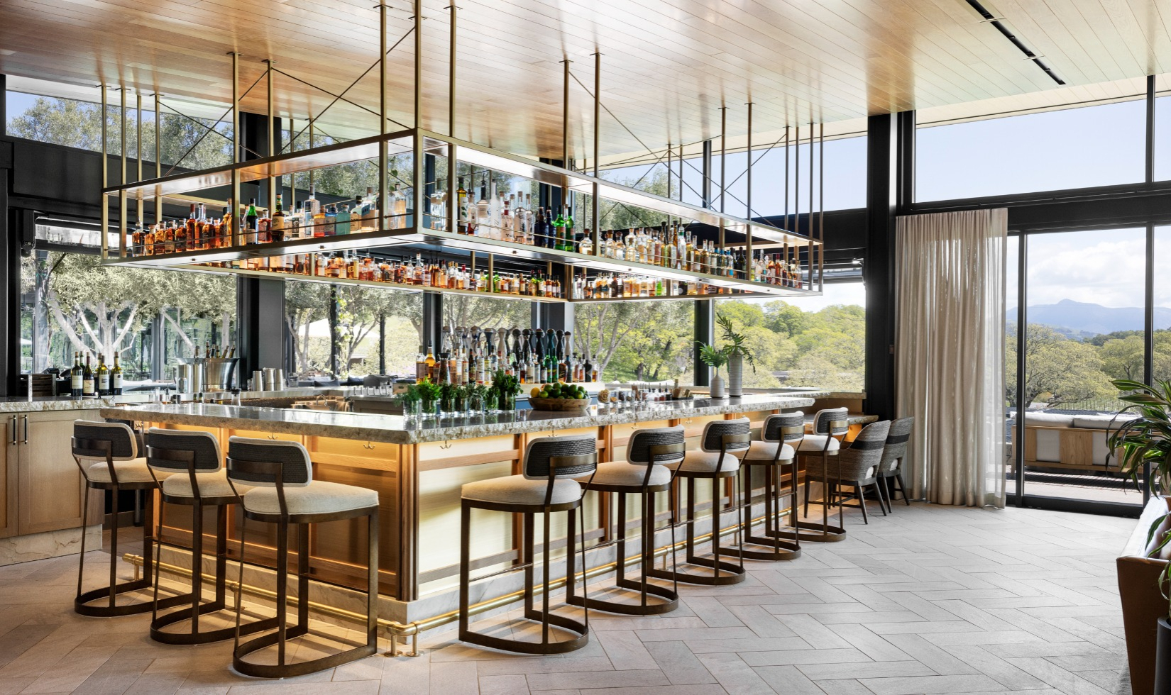 bar with chairs around bar counter with views of the sliding glasses door onto the greenery of the montage resort