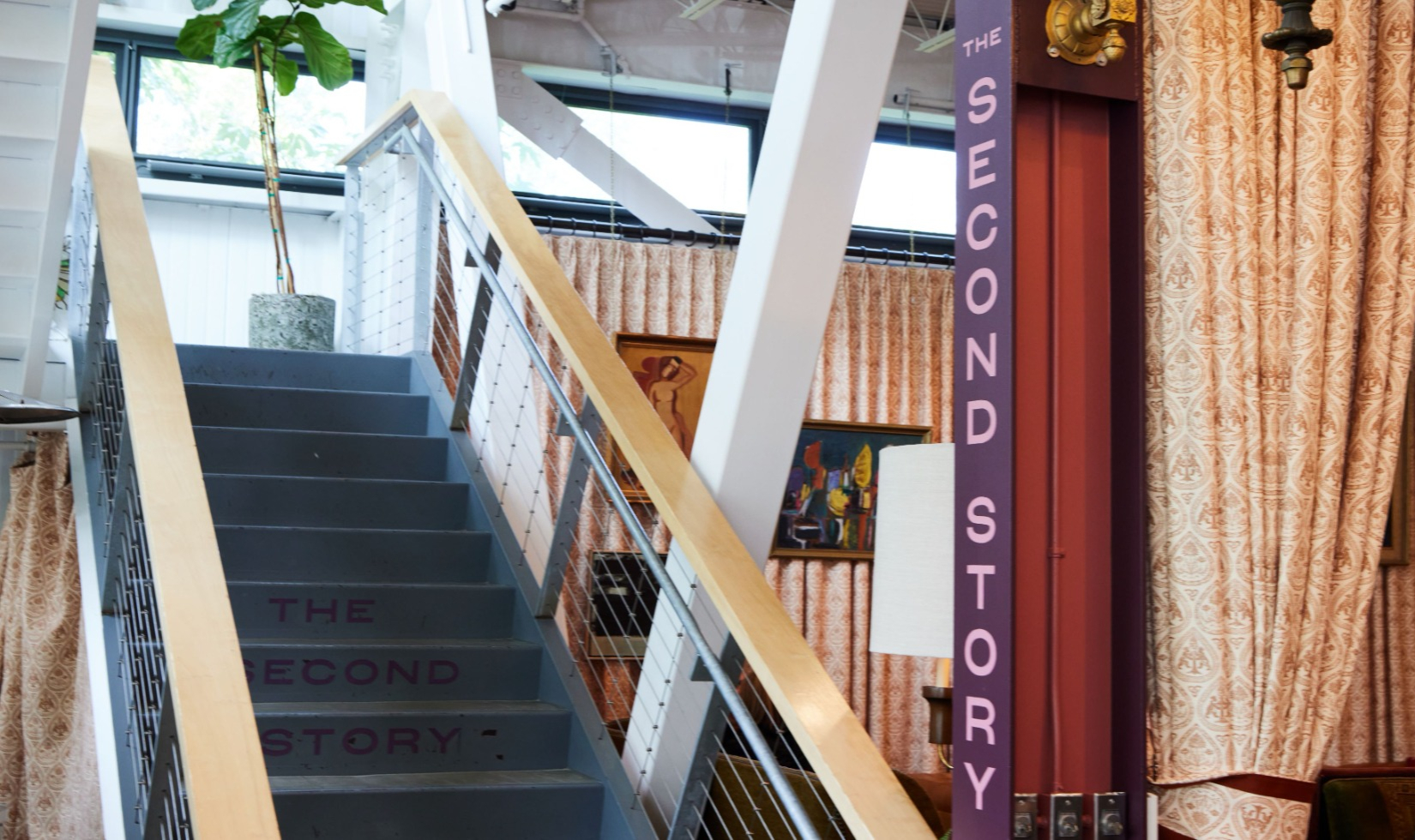 stairs with words the second story painted onto them leading upstairs to a landing