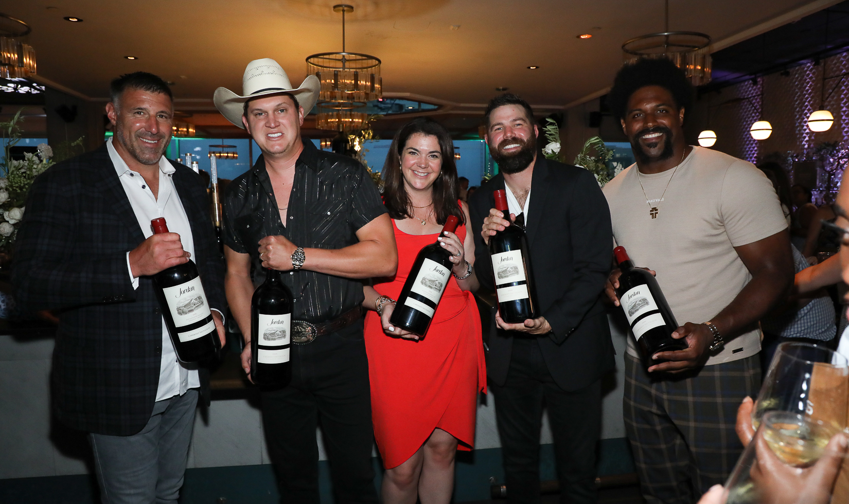 5 persons carrying a big size bottle of Jordan Wine in a bar lounge