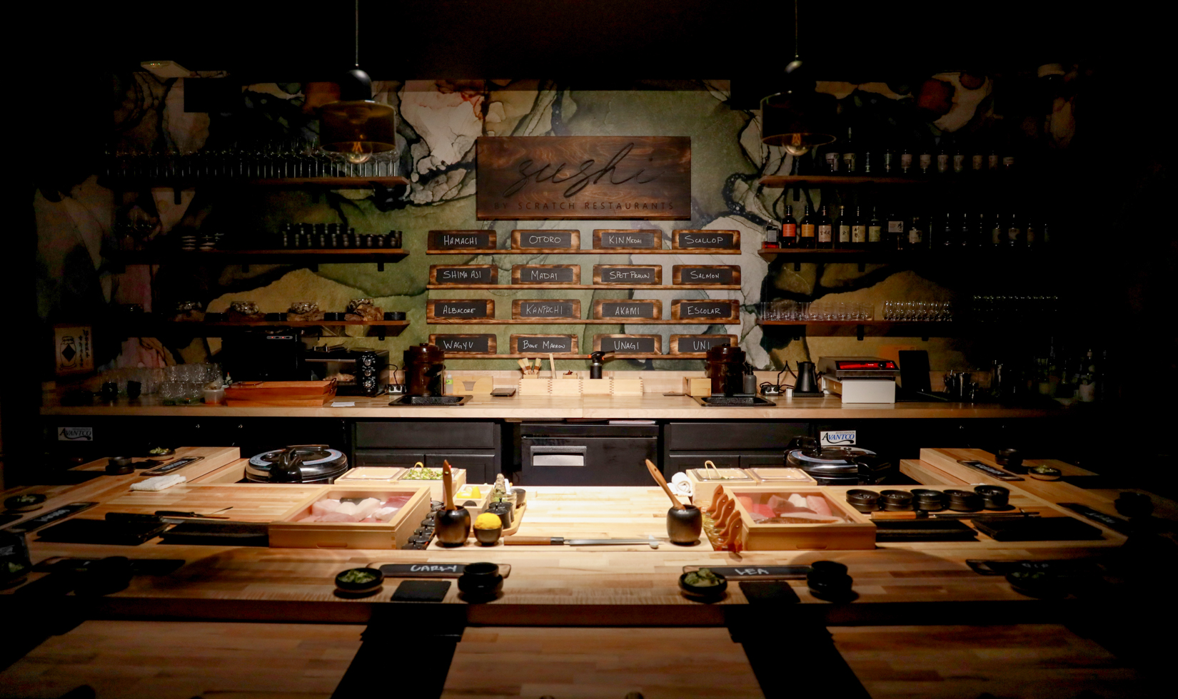 dark eight-person sushi restaurant with menu and open concept cooking space