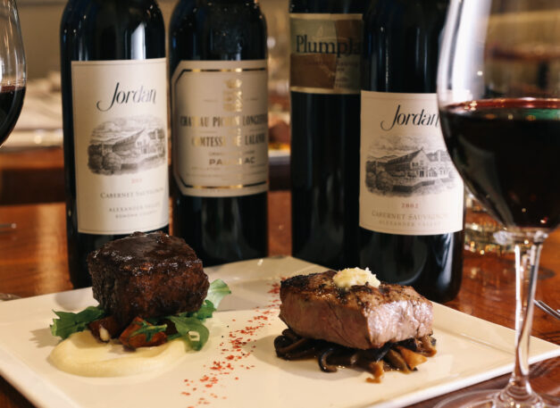 bottles of cabernet on restaurant table with cuts of steak