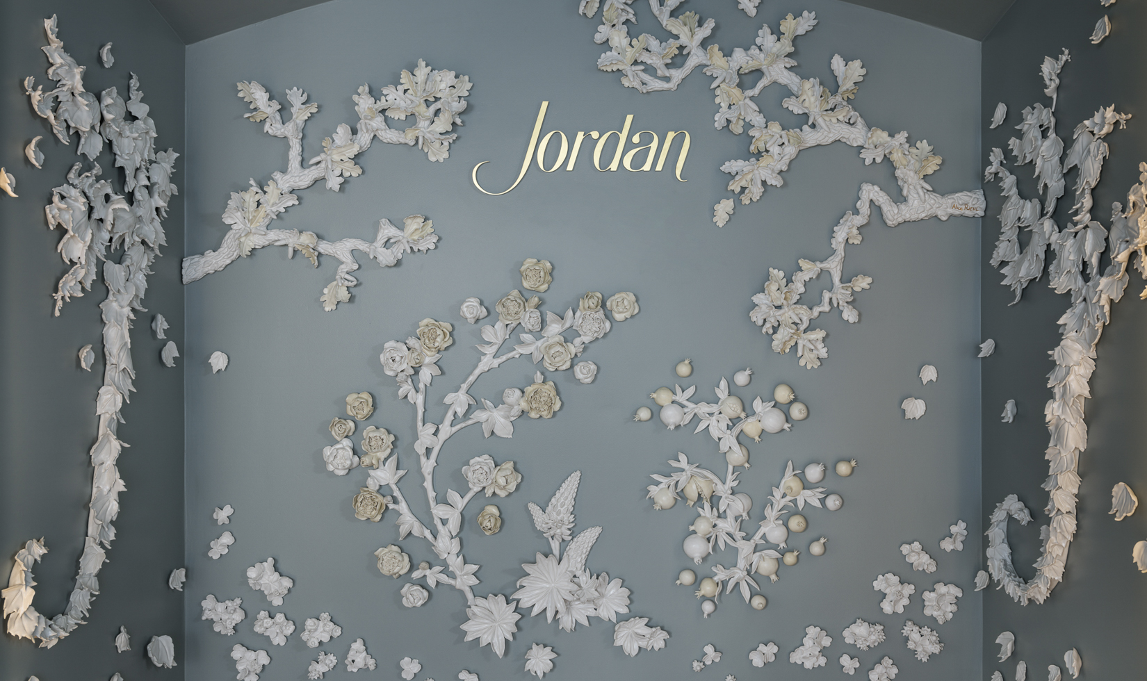 white porcelain wall sculpture featuring flora with the Jordan logo in the middle
