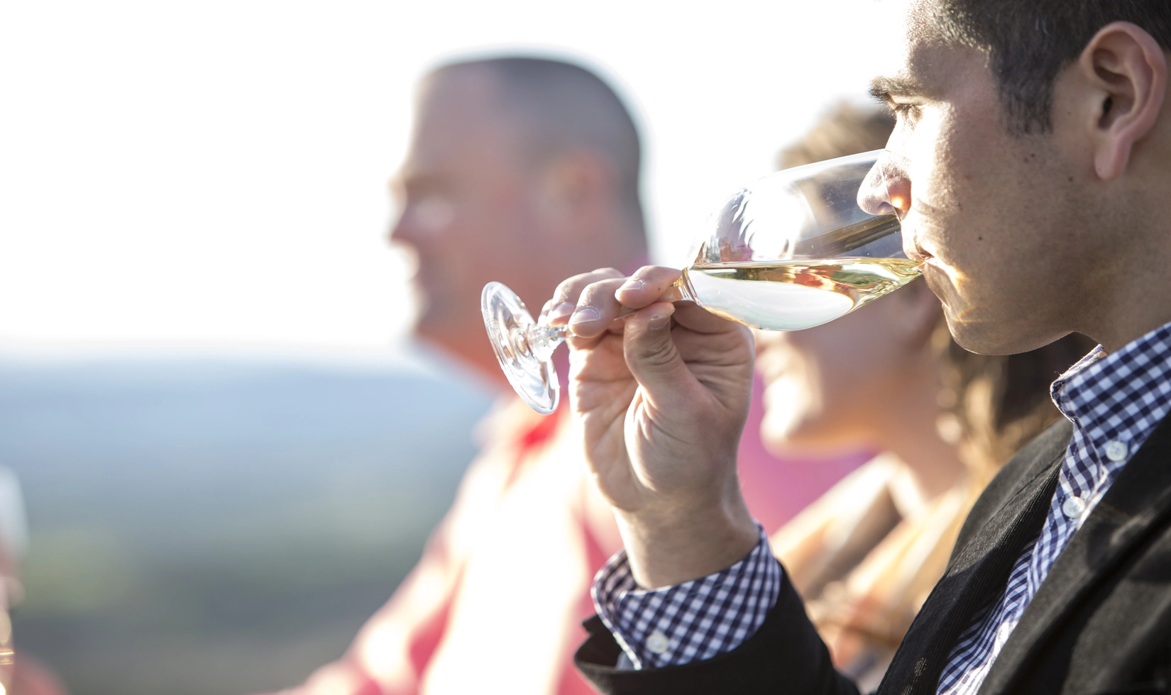 a person drinking white wine along with other people