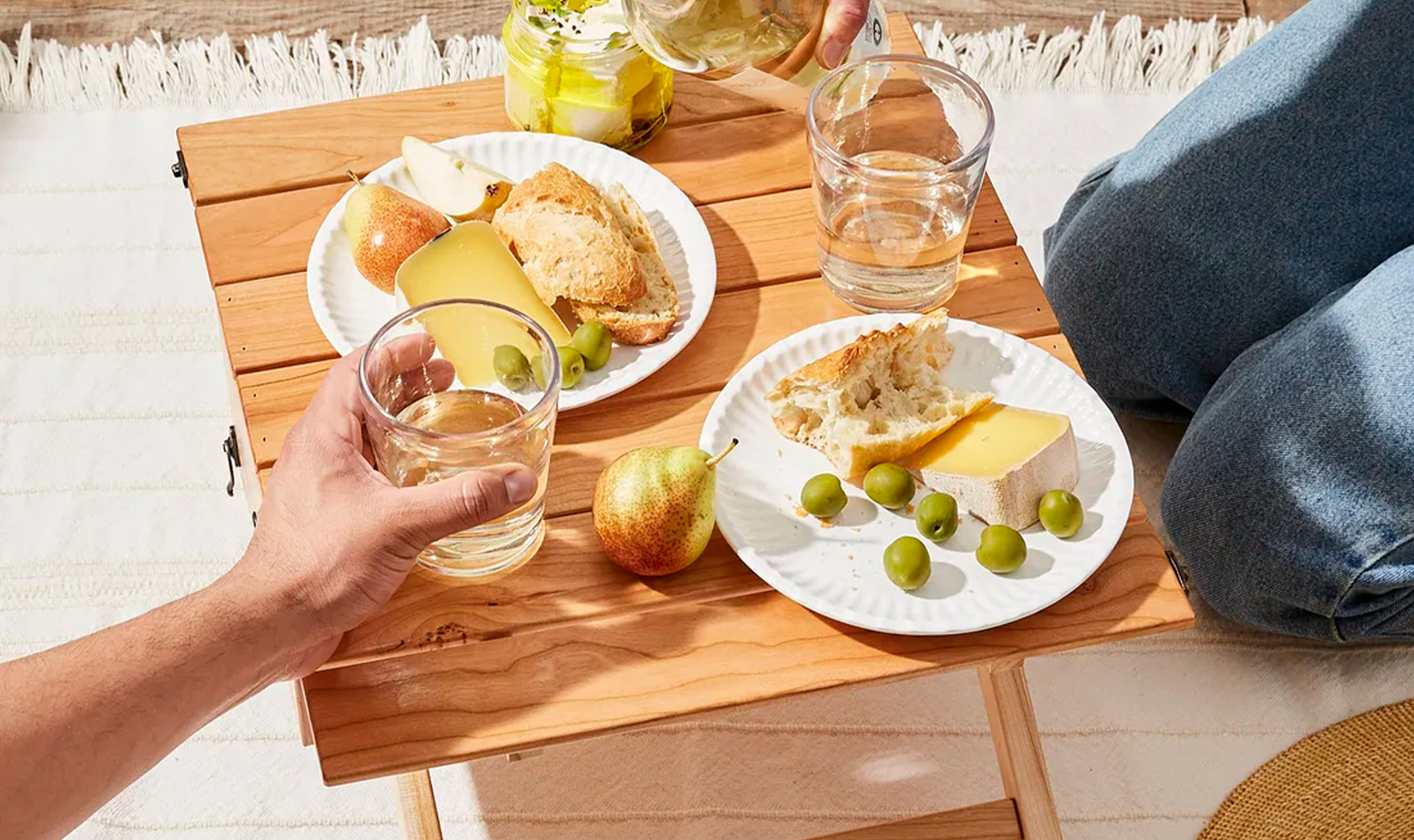 Picnic with cheese, bread, olives, and wine.