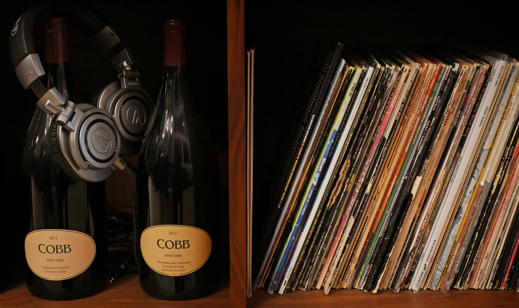 bottles of cobb wine on shelf with headphones draped over bottle next to collection of vinyl records